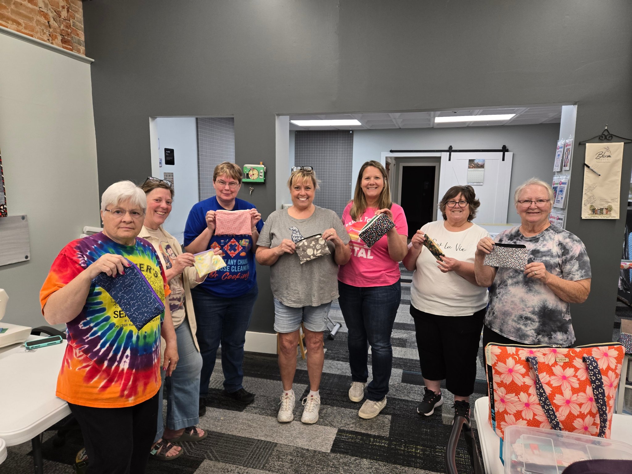 Students showing off their finished zipper bags from class